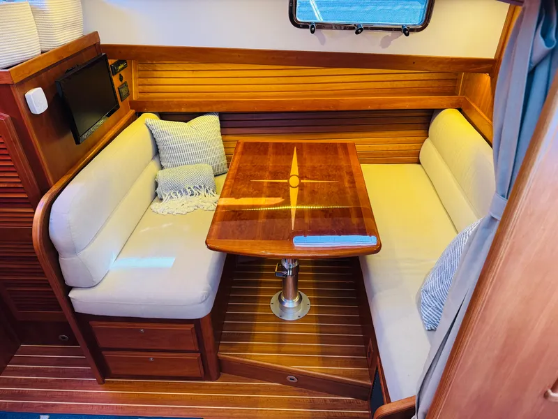 Slide: The Image of 2018 Sabre 42 Salon Express interior with wooden table and cushioned seating. - 15