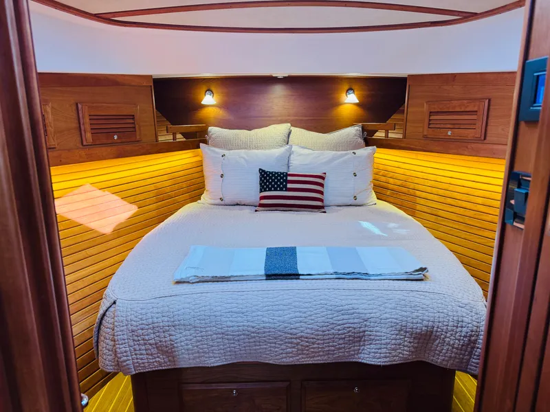 Slide: The Image of Cozy cabin interior of 2018 Sabre 42 Salon Express with wooden paneling and plush bedding. - 18