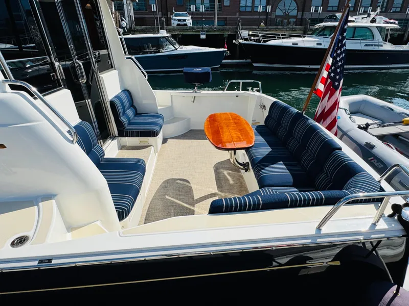 Slide: The Image of 2018 Sabre 42 Salon Express yacht with striped seating and wooden table in the cockpit area. - 2