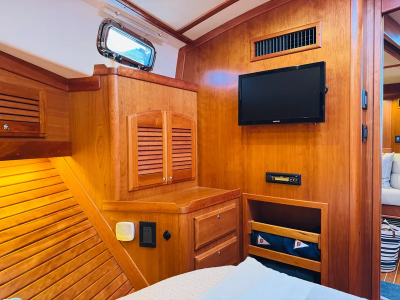 Slide: The Image of 2018 Sabre 42 Salon Express interior with wood paneling, TV, and storage compartments. - 23