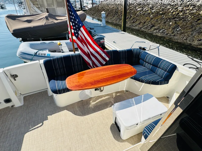 Slide: The Image of 2018 Sabre 42 Salon Express yacht with striped seating and wooden table on deck. - 32