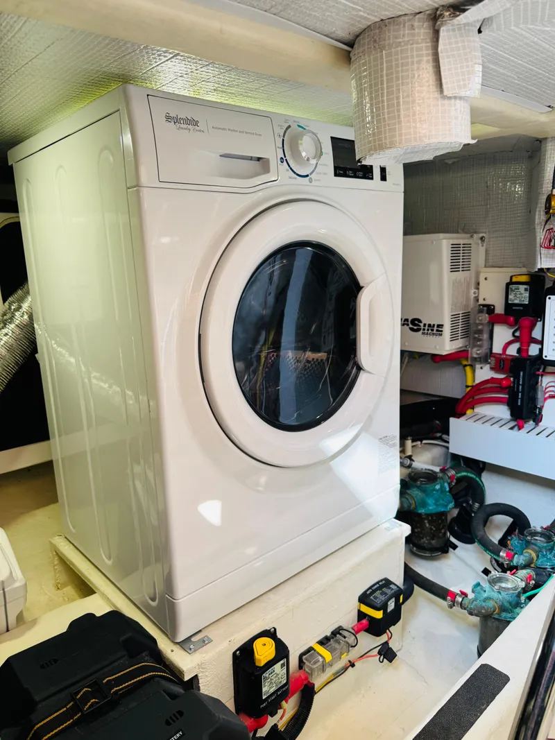 Slide: The Image of Laundry area inside 2018 Sabre 42 Salon Express yacht, featuring a washing machine. - 39