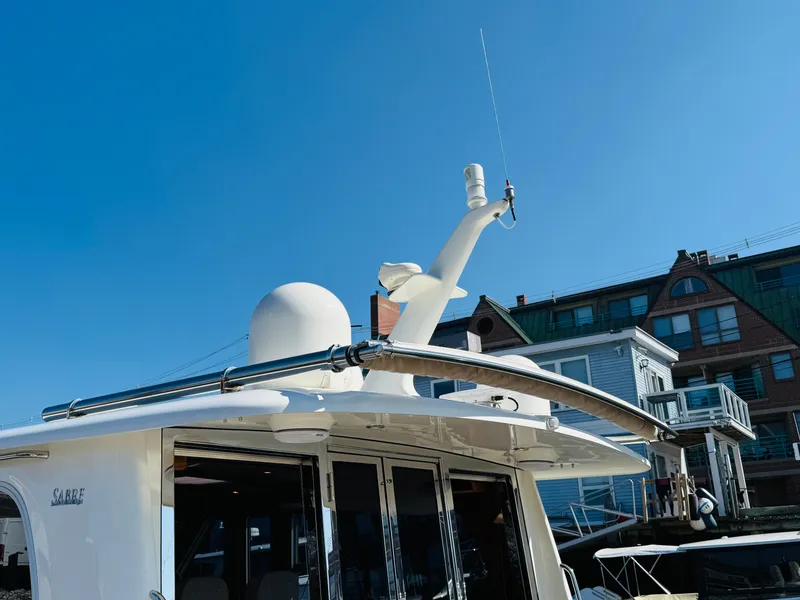 Slide: The Image of 2018 Sabre 42 Salon Express yacht docked, showcasing radar and antenna against a clear blue sky. - 45