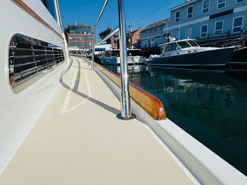 Slide: The Image of 2018 Sabre 42 Salon Express yacht docked in a marina, showcasing sleek design and waterfront buildings. - 49