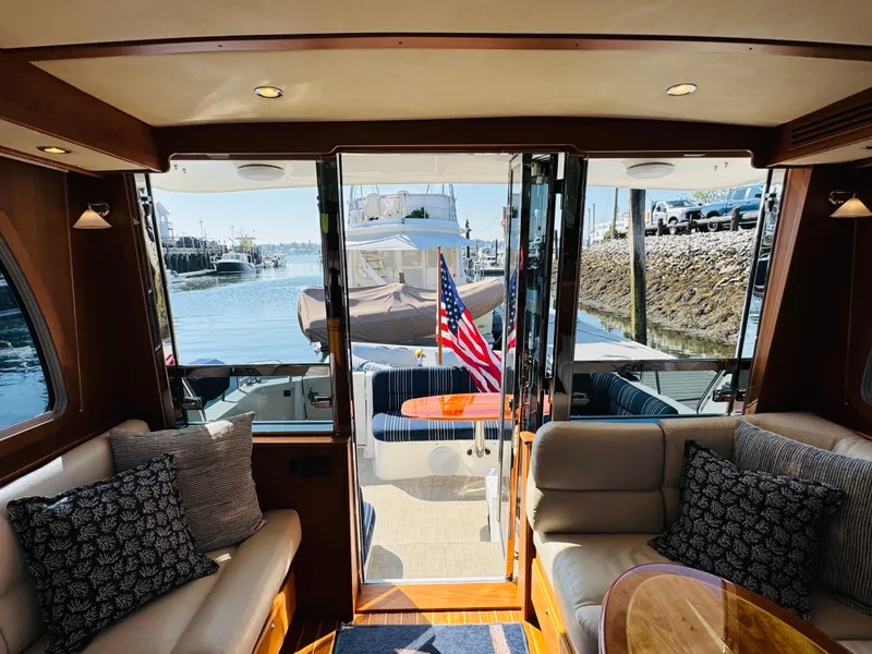Slide: The Image of Interior view of 2018 Sabre 42 Salon Express yacht with American flag and waterfront. - 8