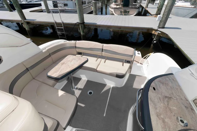 Slide: The Image of 2018 Formula 34 PC yacht cockpit with beige seating and table, docked at marina. - 10
