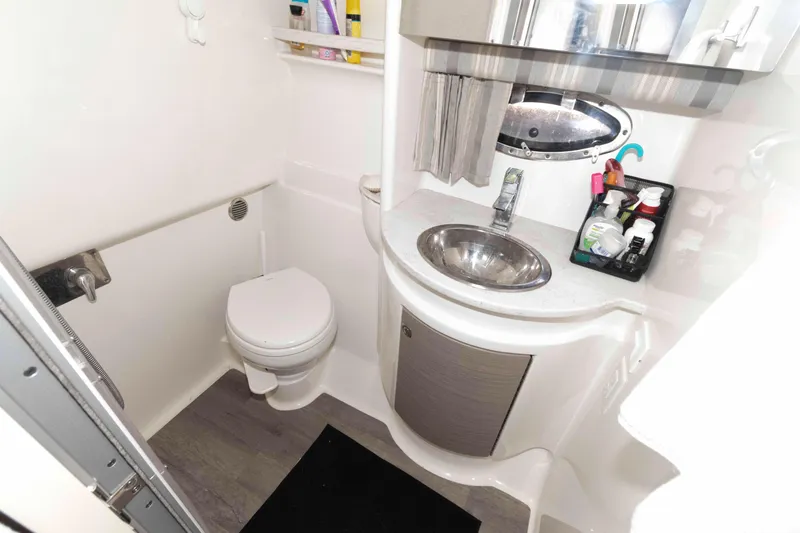 Slide: The Image of 2018 Formula 34 PC boat bathroom with sink, toilet, and storage shelves. - 18
