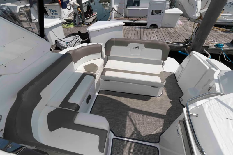 Slide: The Image of 2018 Monterey 295 Sport Yacht interior with cushioned seating and dock view. - 10
