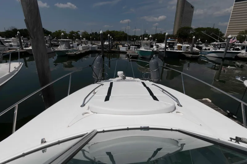 Slide: The Image of 2018 Monterey 295 Sport Yacht docked in a marina, surrounded by various boats. - 12