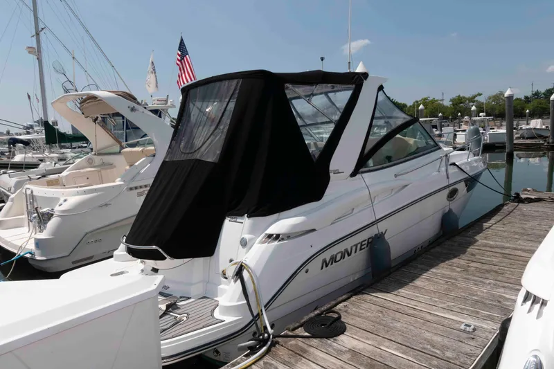 Slide: The Image of 2018 Monterey 295 Sport Yacht docked at marina, covered with black canopy. - 3