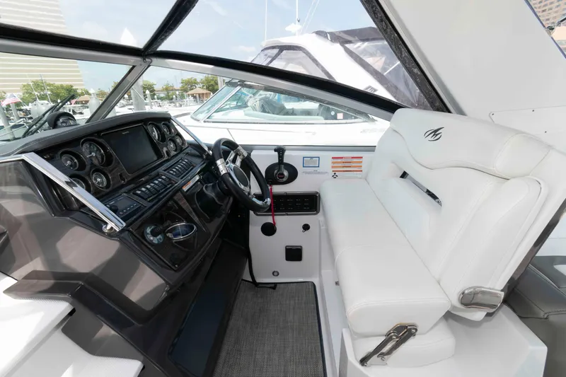 Slide: The Image of 2018 Monterey 295 Sport Yacht cockpit with modern dashboard and white seating. - 6
