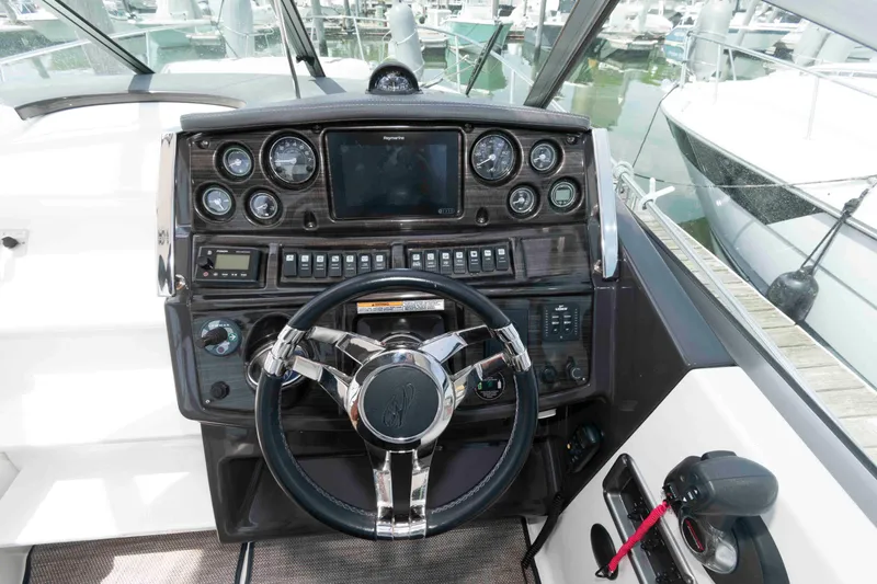 Slide: The Image of 2018 Monterey 295 Sport Yacht dashboard with steering wheel and control panel. - 8