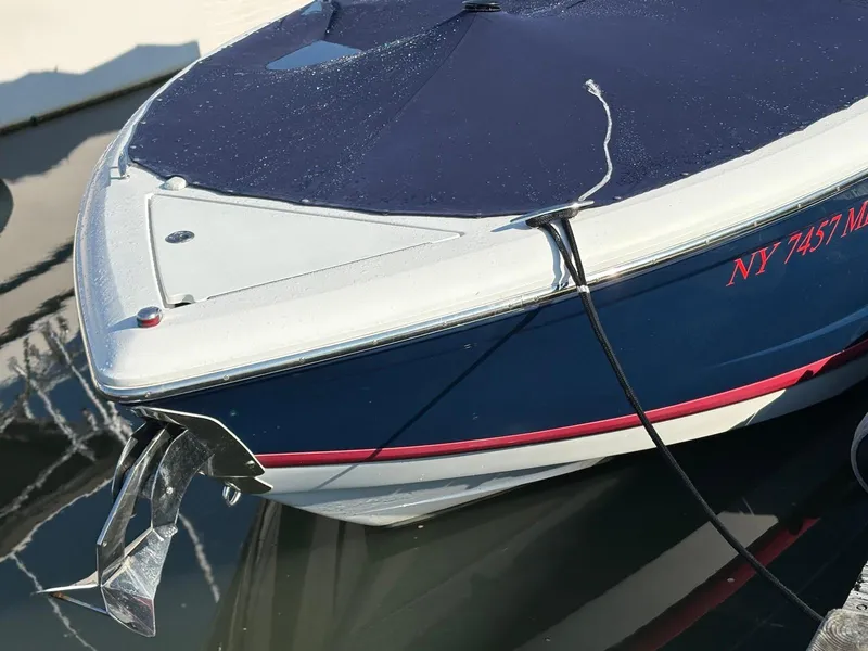 Slide: The Image of 2012 Cobalt A28 boat with cover, docked, showing registration number NY 7457 ME. - 10