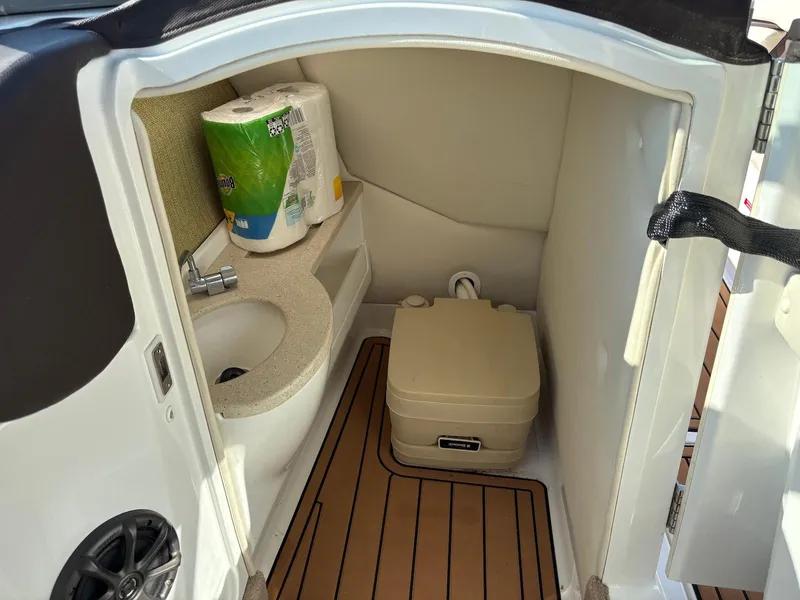 Slide: The Image of 2012 Cobalt A28 boat interior with compact bathroom, sink, and portable toilet. - 30