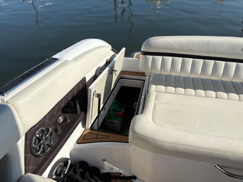 Slide: The Image of 2012 Cobalt A28 boat interior with white seating and storage compartment open. - 31