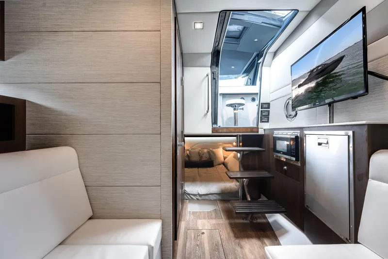 Slide: The Image of 2023 Cruisers Yachts 42 GLS OB interior with modern seating, TV, and kitchenette. - 7