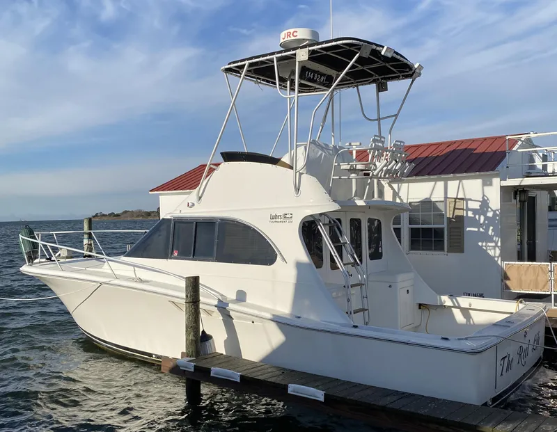 The Image of 1992 Luhrs Tournament 320 Convertible boat docked by a waterfront building. - 0