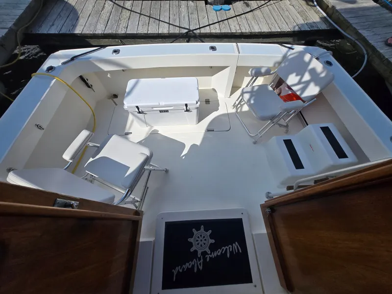 Slide: The Image of 1992 Luhrs Tournament 320 Convertible boat deck with chairs and cooler at dock. - 2