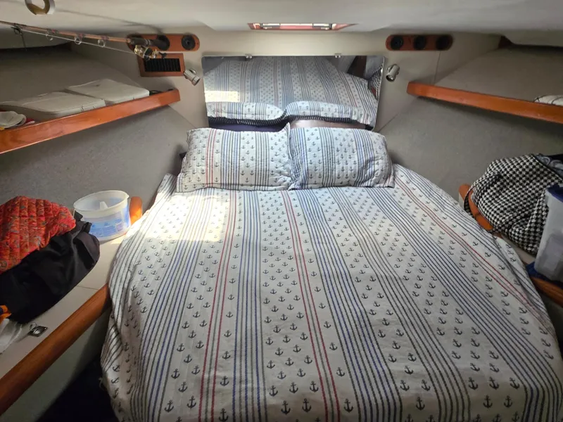Slide: The Image of Cozy cabin interior of 1992 Luhrs Tournament 320 Convertible with nautical-themed bedding. - 3