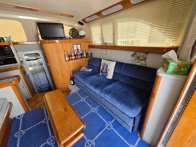 Slide: The Image of Interior of 1992 Luhrs Tournament 320 Convertible with blue sofa and wooden accents. - 7
