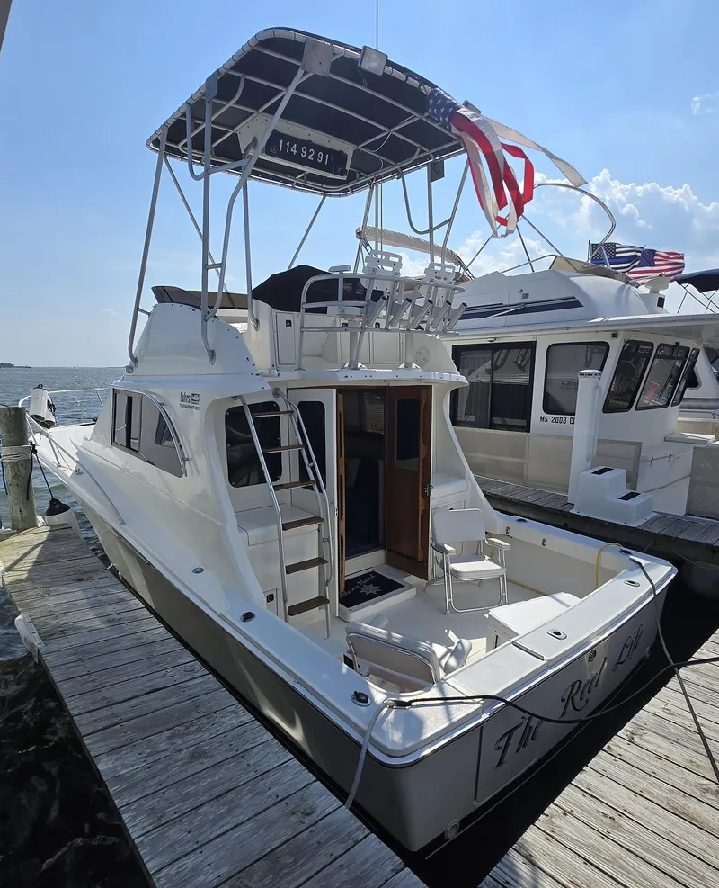 Slide: The Image of 1992 Luhrs Tournament 320 Convertible boat docked at marina, rear view. - 9