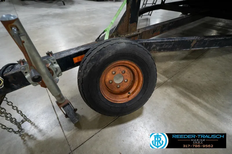 Slide: The Image of 1988 Landau 20 Adventurer pontoon boat interior with blue and white seating, steering console. - 12