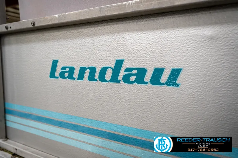 Slide: The Image of 1988 Landau 20 Adventurer pontoon boat interior with blue carpet and seating. - 13