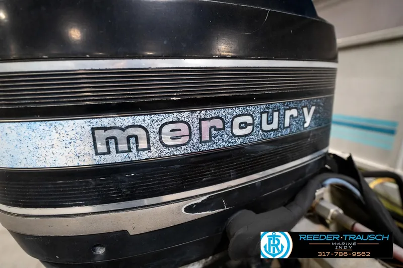 Slide: The Image of 1988 Landau 20 Adventurer pontoon boat interior with blue and gray seating in a showroom. - 14