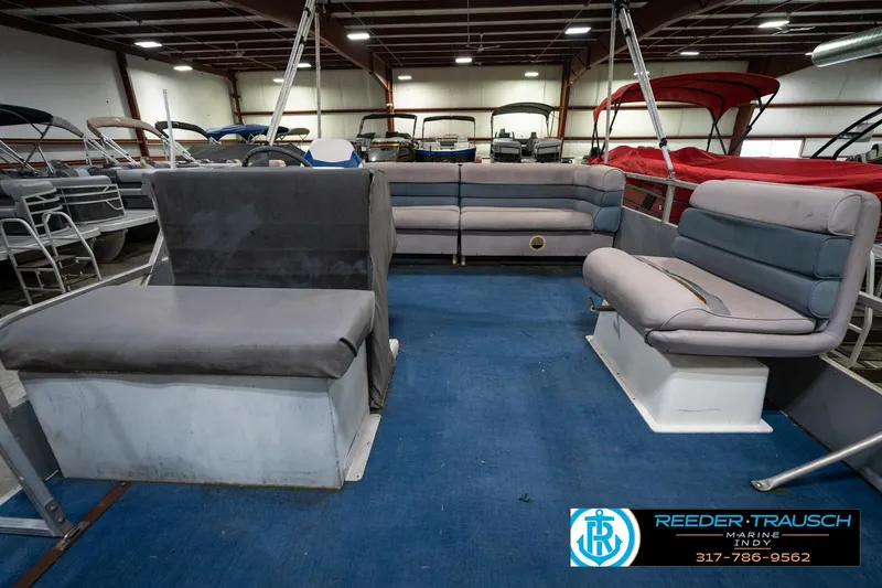 Slide: The Image of 1988 Landau 20 Adventurer boat interior with blue and gray seating in a showroom. - 21