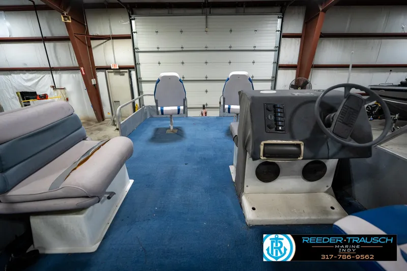 Slide: The Image of 1988 Landau 20 Adventurer boat interior with blue and white seating in a showroom. - 23