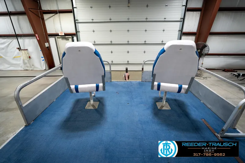 Slide: The Image of 1988 Landau 20 Adventurer boat interior with steering wheel and blue seating. - 24