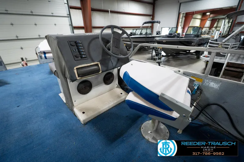 Slide: The Image of 1988 Landau 20 Adventurer boat interior with blue carpet and worn seating. - 29