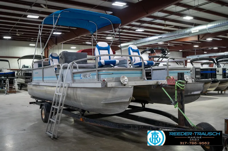 Slide: The Image of 1988 Landau 20 Adventurer pontoon boat with blue canopy in indoor showroom. - 4