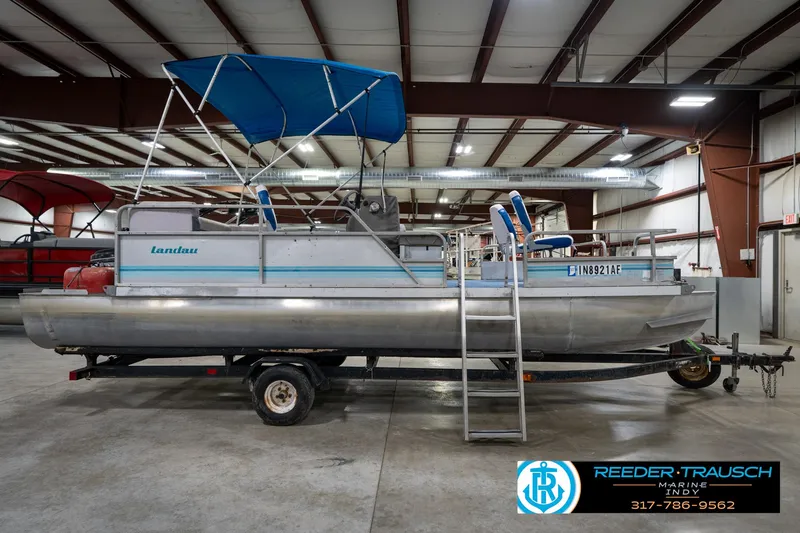 Slide: The Image of 1988 Landau 20 Adventurer pontoon boat with blue canopy in indoor storage. - 5
