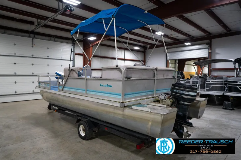 Slide: The Image of 1988 Landau 20 Adventurer pontoon boat with blue canopy in indoor storage. - 8