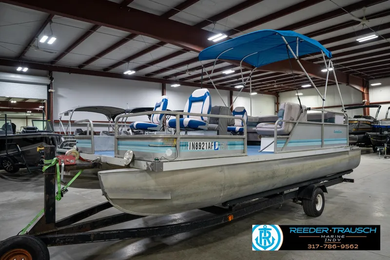 Slide: The Image of 1988 Landau 20 Adventurer pontoon boat with blue canopy in indoor storage. - 9