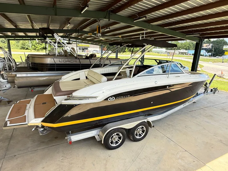 Slide: The Image of 2012 Cobalt 276 boat on trailer in covered storage, alongside other boats. - 3