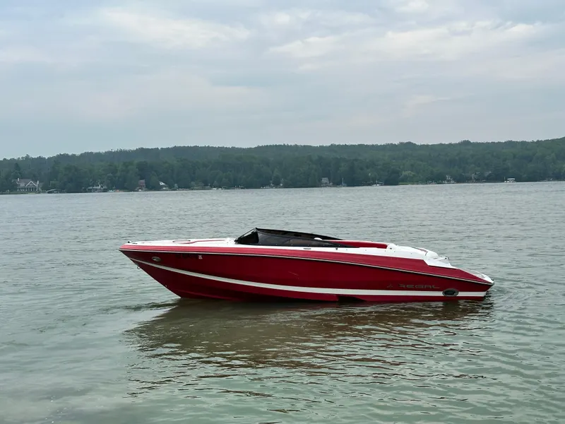 Slide: The Image of Red 2008 Regal 2200 RS boat on a calm lake with forested shoreline. - 4