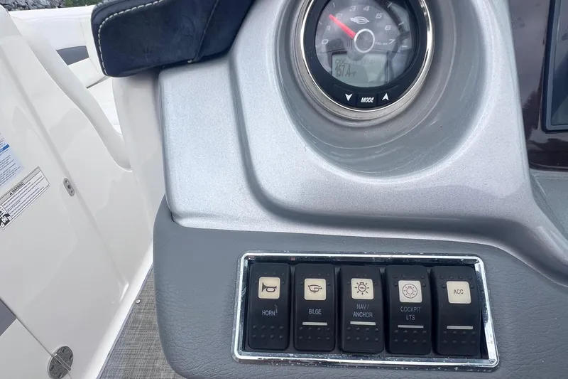Slide: The Image of Dashboard controls of a 2015 Chaparral 224 Sunesta boat, featuring various switches and gauges. - 12