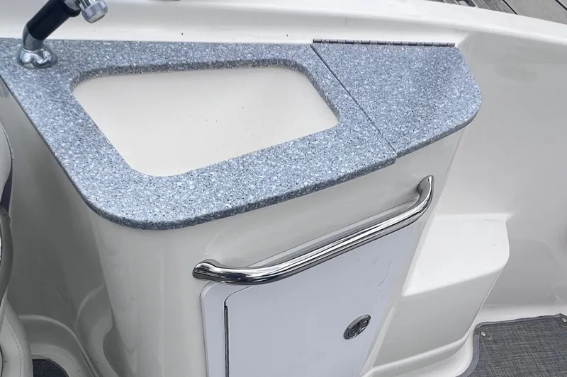 Slide: The Image of Storage compartment in a 2015 Chaparral 224 Sunesta boat with fire extinguisher and equipment. - 18