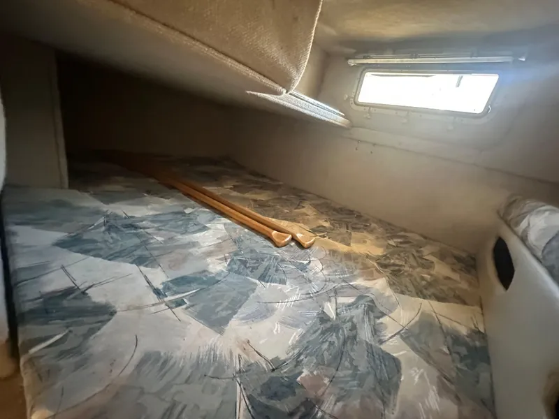 Slide: The Image of Interior cabin of a 1998 Wellcraft 260 boat with patterned bedding and a small window. - 10