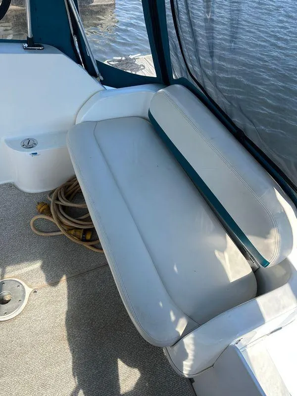Slide: The Image of White seating area on a 1998 Wellcraft 260 boat, with coiled rope nearby. - 2