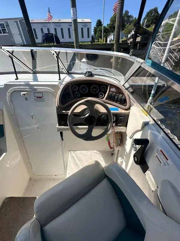 Slide: The Image of 1998 Wellcraft 260 boat cockpit with steering wheel and dashboard controls. - 4