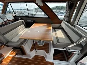 Slide: The Image of 2022 Cutwater C-32 CB interior with seating and table, docked at marina. - 4