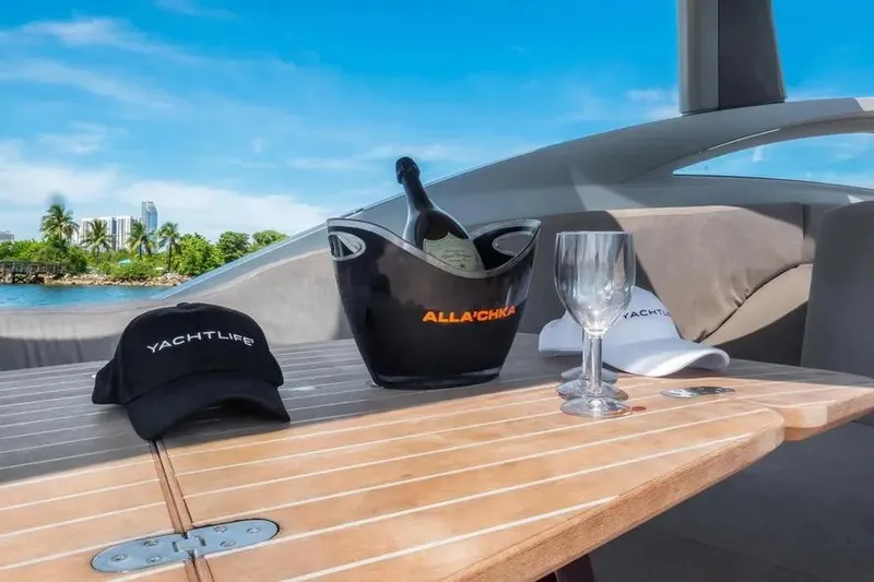 Slide: The Image of Luxury Tecnomar Evo 55 yacht deck with champagne, glasses, and caps under clear blue sky. - 11