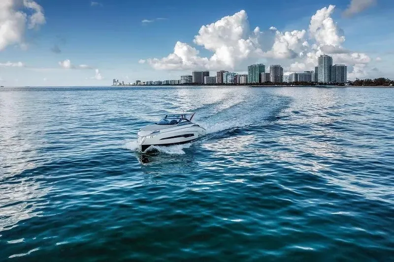 Slide: The Image of Tecnomar Evo 55 yacht cruising on blue ocean near city skyline, 2017 model. - 3