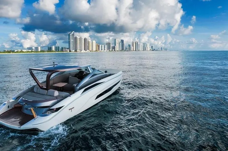 Slide: The Image of Luxurious Tecnomar Evo 55 yacht cruising near a city skyline under a vibrant blue sky. - 5