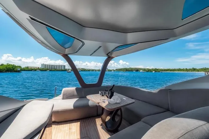 Slide: The Image of Luxurious Tecnomar Evo 55 yacht interior with ocean view, featuring elegant seating and table setup. - 7