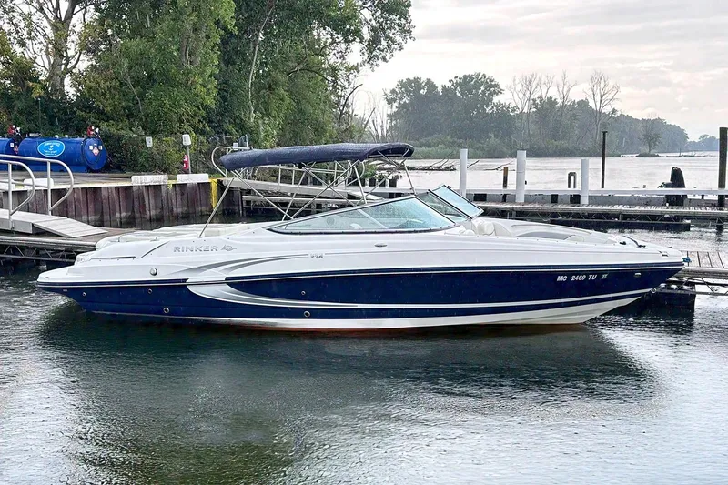 The Image of 2015 Rinker 276 Captiva Bowrider docked by a scenic waterfront. - 0