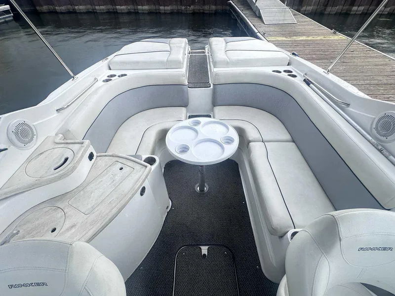 Slide: The Image of 2015 Rinker 276 Captiva Bowrider interior with seating and table, docked by the water. - 12